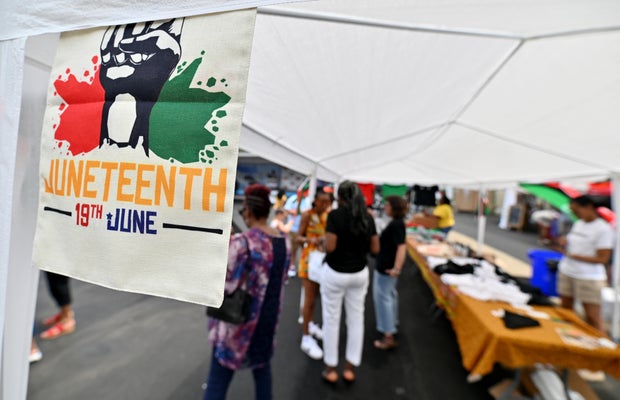 A Juneteenth flag hangs on one of the vendor tents during a