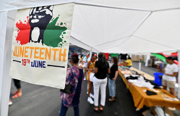 A Juneteenth flag hangs on one of the vendor tents during a 