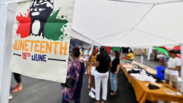 A Juneteenth flag hangs on one of the vendor tents during a 