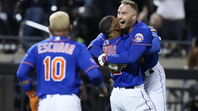 New York Mets' Francisco Lindor, center, hugs Brandon Nimmo, right, after Nimmo drove in the winning run with a double during the 10th inning of the team's baseball game against the New York Yankees on Wednesday, June 14, 2023, in New York. 