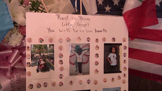 A poster board reading "Rest in peace little angel, you will be in our hearts" displays photos of Anadith Tanay Reyes Alvarez in the South Bronx on June 16, 2023. 
