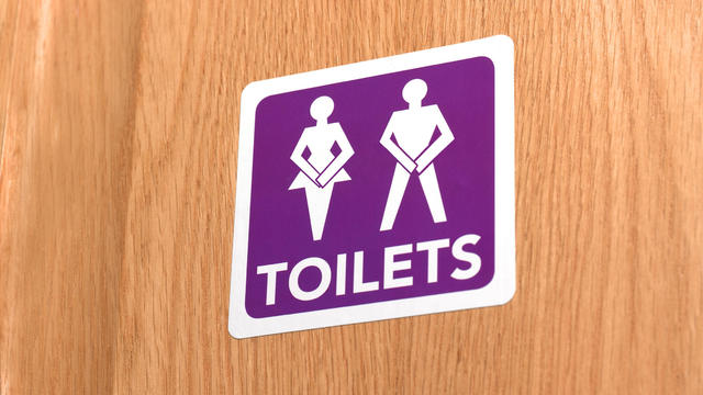 Gender neutral desperate for the toilet, illustrated on door sign 