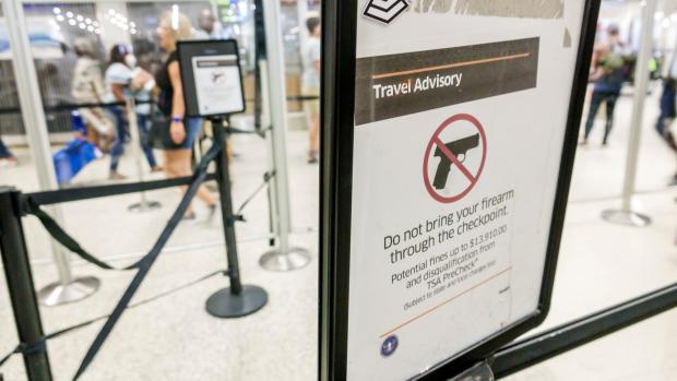 A sign at a TSA checkpoint at Miami International Airport reminds travelers not to bring firearms through security. 