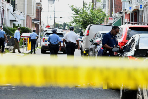 Police officers work at the scene the day after a mass shooting in the Kingsessing section of southwest Philadelphia, Pennsylvania, July 4, 2023. 