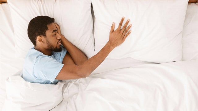Lonely black man sleeping in bed and missing his partner