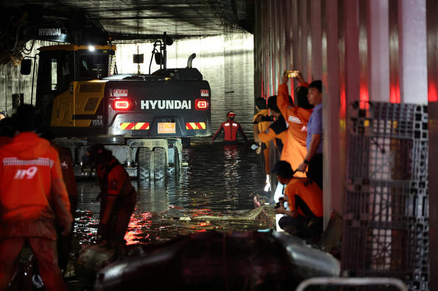 Rescue workers take part in a search and rescue operation inside an underpass that has been submerged by a flooded river caused by torrential rain in Cheongju 