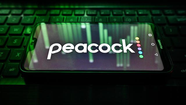 In this photo illustration, a Peacock logo is displayed on a 