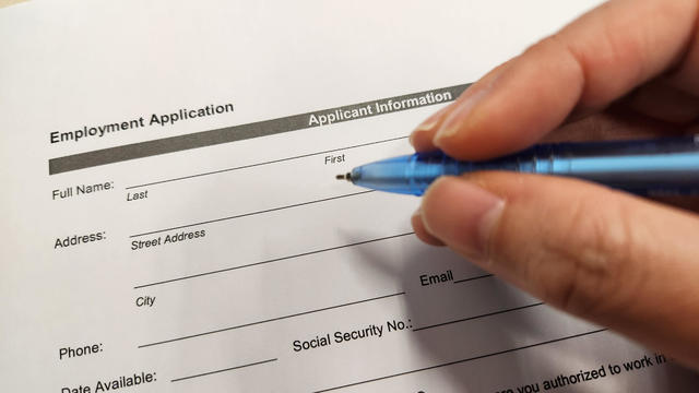 Job seeker filling up employment application form 