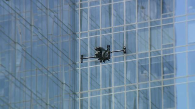 A drone flies in New York City in front of a skyscraper. 