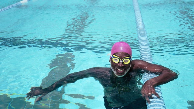 Mature man in swimming pool, smiling, portrait 