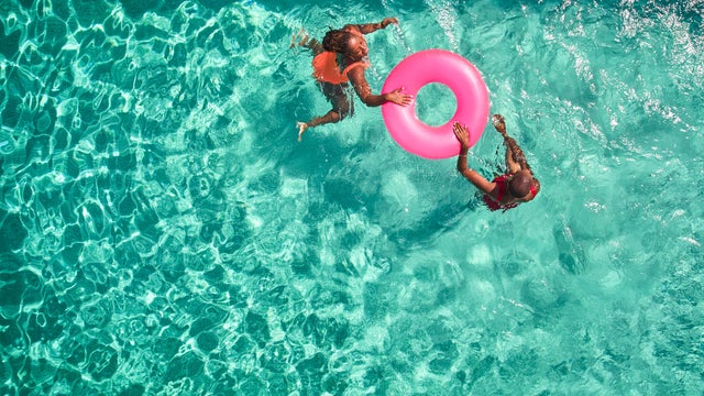 Aerial view point of mother and daughter swimming together. 