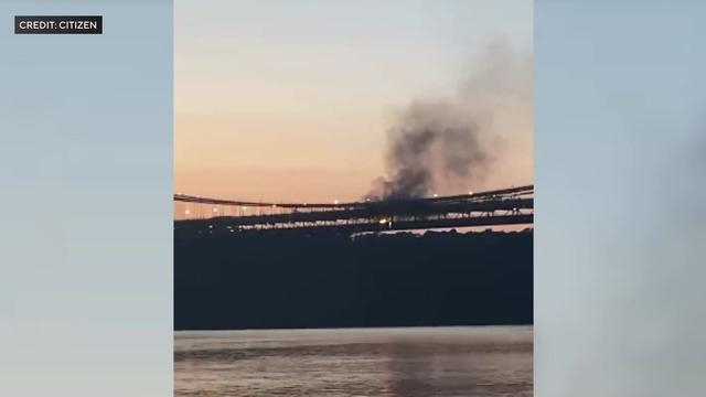 Black smoke billows from the George Washington Bridge around sunset. 