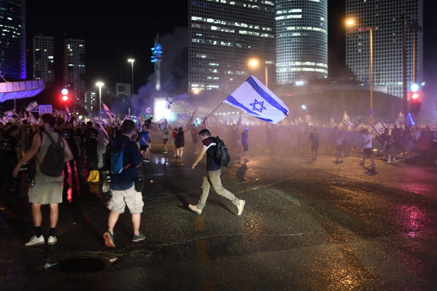 Israeli protesters confront police during a rally against the Israeli goverment's judicial overhaul bills in the coastal city of Tel Aviv, July 24, 2023