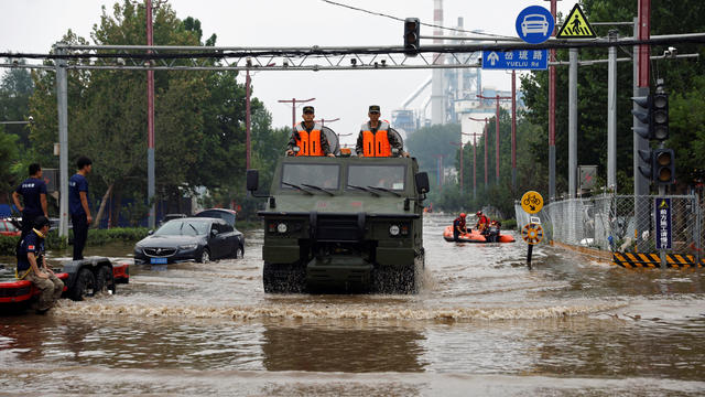Paramilitary police vehicle wades through floodwaters in Beijing 