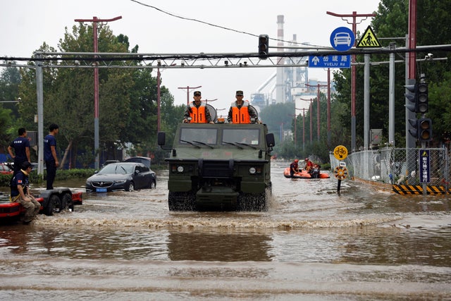 Paramilitary police vehicle wades through floodwaters in Beijing