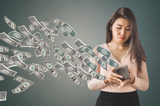 poor Asian woman holding  purse having problem with money flying away, over spending concept 