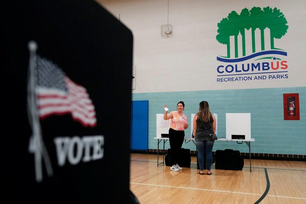 A volunteer helps voters cast their ballots during a special election for Issue 1 in Columbus, Ohio, on Aug. 8, 2023.