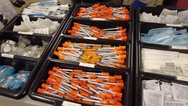 Multiple containers containing syringes and needles. 