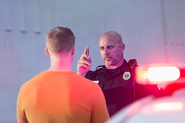 Policeman performing sobriety test on driver 