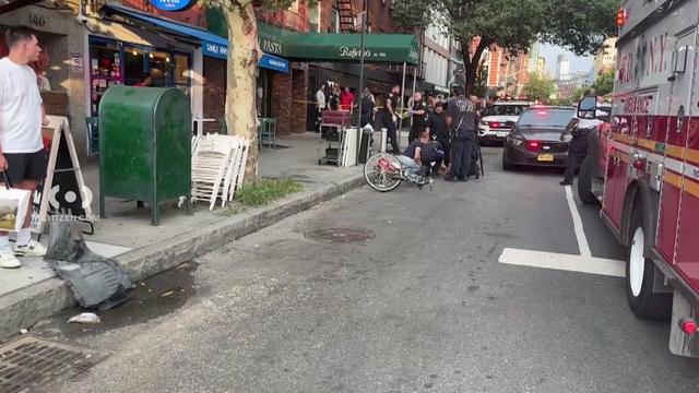 First responders crowd around a cyclist on a Greenwich Village street. 