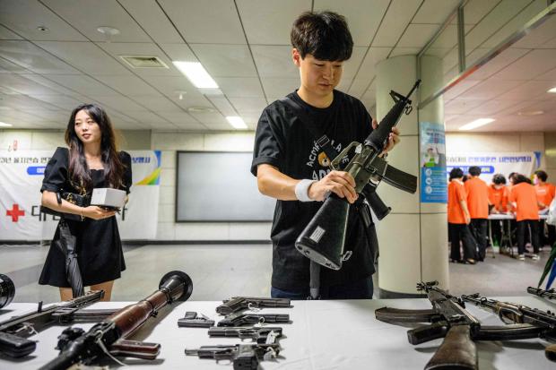 A man holds a display gun during a civil defense drill against possible attacks by North Korea, in a subway station in Seoul on August 23, 2023. 