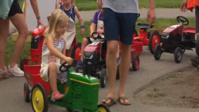 girl riding toy tractor at minnesota state fair 