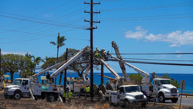 FILE PHOTO: Workers repair utility lines in the fire ravaged town of Lahaina 