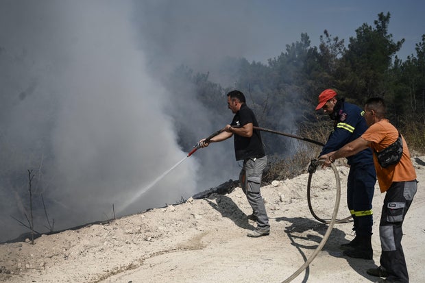 Firefighters and volunteers combat a wildfire spreading in the Dadia forest, one of the most important areas in Europe for birds of prey, as wildfire rages, in Dadia near Alexandroupoli, north Greece,Hundreds of firefighters in Greece struggled Thursday to tame major wildfires burning for a sixth day, leaving 20 dead and prompting growing outrage among stricken residents