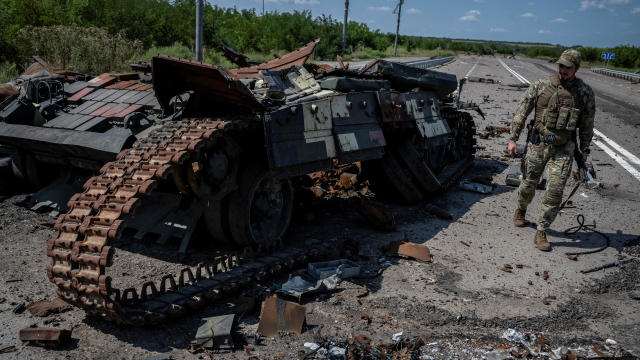 A Ukrainian serviceman walks near a destroyed Ukrainian tank near the village of Robotyne 