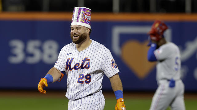 DJ Stewart #29 of the New York Mets celebrates his tenth inning game winning hit by pitch as Adolis Garcia #53 of the Texas Rangers walks off the field at Citi Field on August 30, 2023 in New York City. 