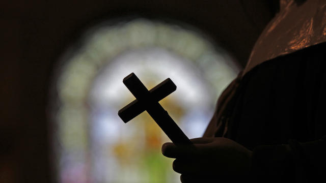 A silhouette of a crucifix and a stained glass window are seen inside a Catholic Church in New Orleans, Dec. 1, 2012. 