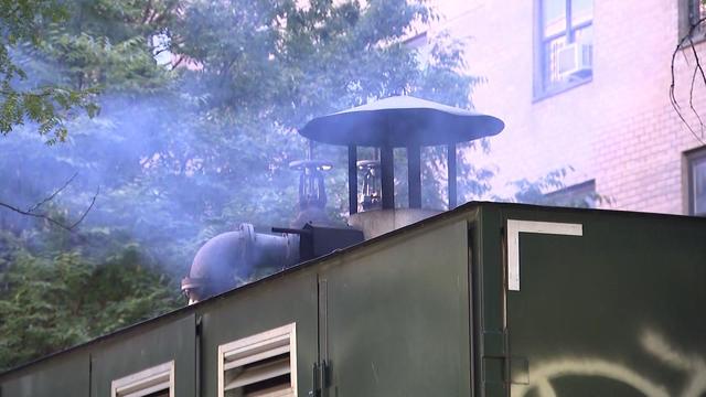 A mobile boiler outside NYCHA housing spews black smoke. 