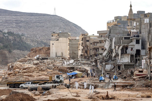Rescue teams walk in a destroyed area in Libya's eastern city of Derna, Sept. 18, 2023, following deadly flash floods