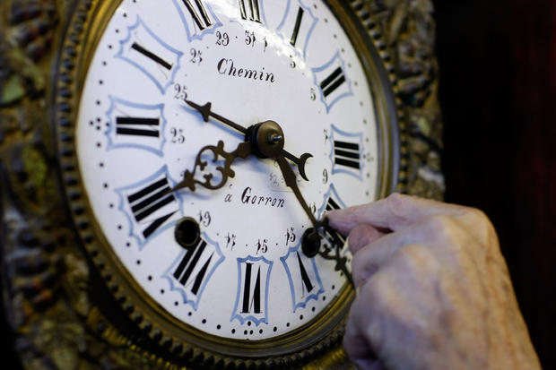 Howie Brown adjusts the time on a clock back one hour for the end of daylight saving time at Brown's Old Time Clock Shop, Nov. 2, 2007, in Plantation, Florida. 