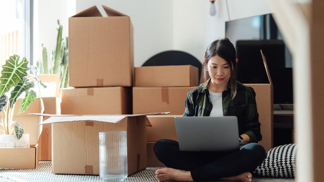 Woman using laptop in new home 