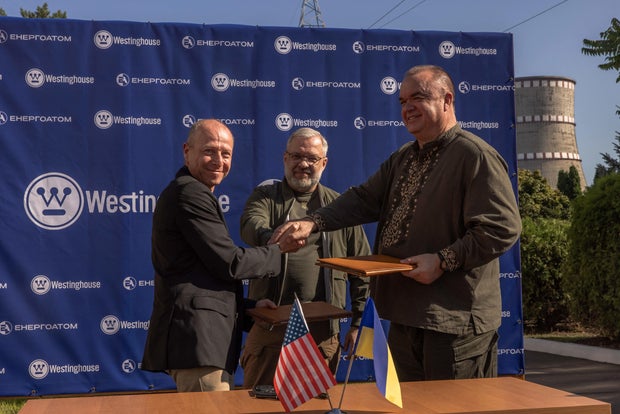 (From L) President and CEO of the Westinghouse Electric Company Patrick Fragman, Ukrainian Minister of Energy German Galushchenko and President of Energoatom Petro Kotin shake hands after the first load of Westinghouse nuclear fuel was fed into the Soviet-era reactors at the Rivne Nuclear Power Plant, in Varash, Ukraine, Sept. 10, 2023