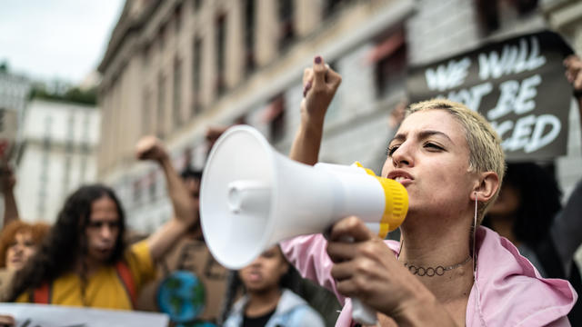 Young woman leading a demonstration using a megaphone 