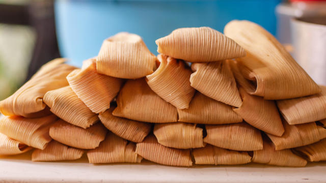 Delicious traditional Mexican tamales piled on a table 