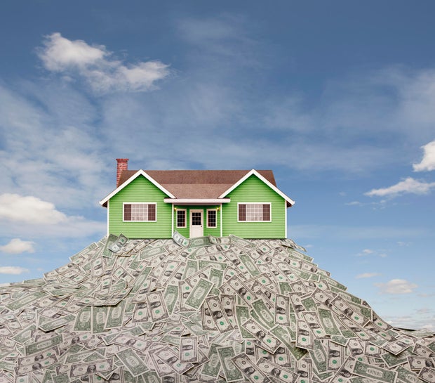 House sitting on pile of dollar bills