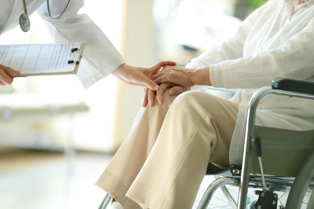 Doctor examining patient in wheelchair 