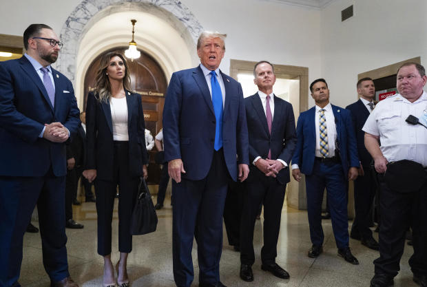 Former President Donald Trump speaks with journalists before entering a courtroom in New York on Monday, Oct. 2, 2023, to attend the start of his civil fraud trial. 