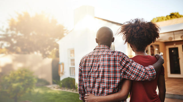 Back view, black couple and hug outdoor at house, real estate and new loan for luxury home. Man, woman and people in front of property investment, moving and dream neighborhood for building mortgage 