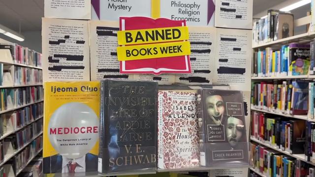 Four books on display at a library under a sign reading "Banned Books Week." 