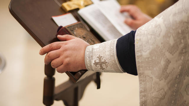 Hands of priest on pulpit 