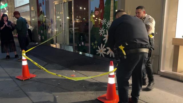 A police officer puts up crime scene tape outside the entrance to a Whole Foods in Midtown. 