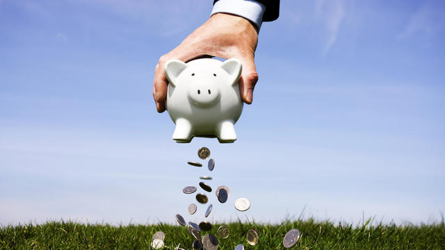 Businessman shaking a piggy bank 