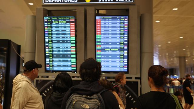 Passengers look at a departure board at Ben Gurion Airport near Tel Aviv, Israel, on October 7, 2023, as flights are canceled because of the Hamas surprise attacks. 