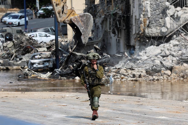 An Israeli soldier patrols near a police station following a mass infiltration by Hamas gunmen from the Gaza Strip, in Sderot