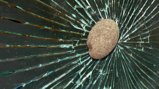 Stone hits and shatters the window glass 