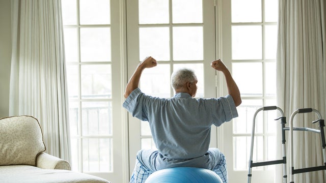 Senior African American man on fitness ball at home 